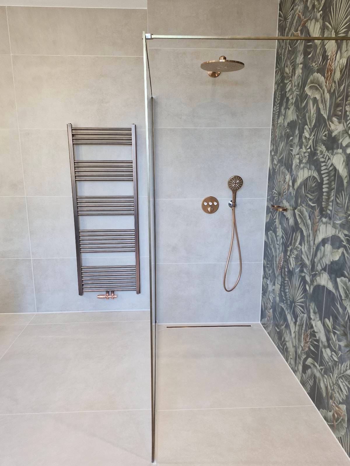 Douche à l'italienne avec papier peint tropical et finitions cuivrées