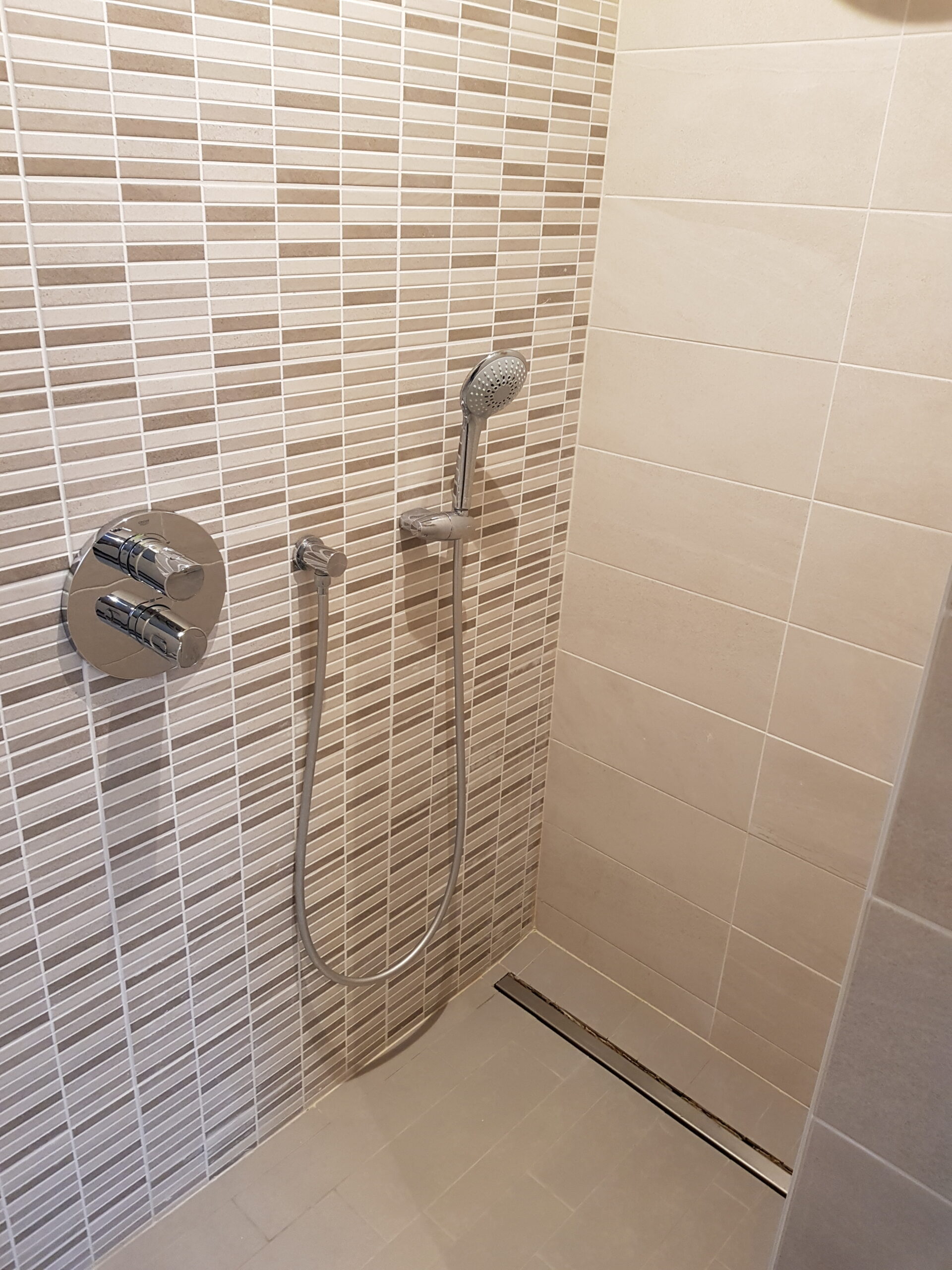 Douche à l'italienne habillée d'une mosaïque beige et grise