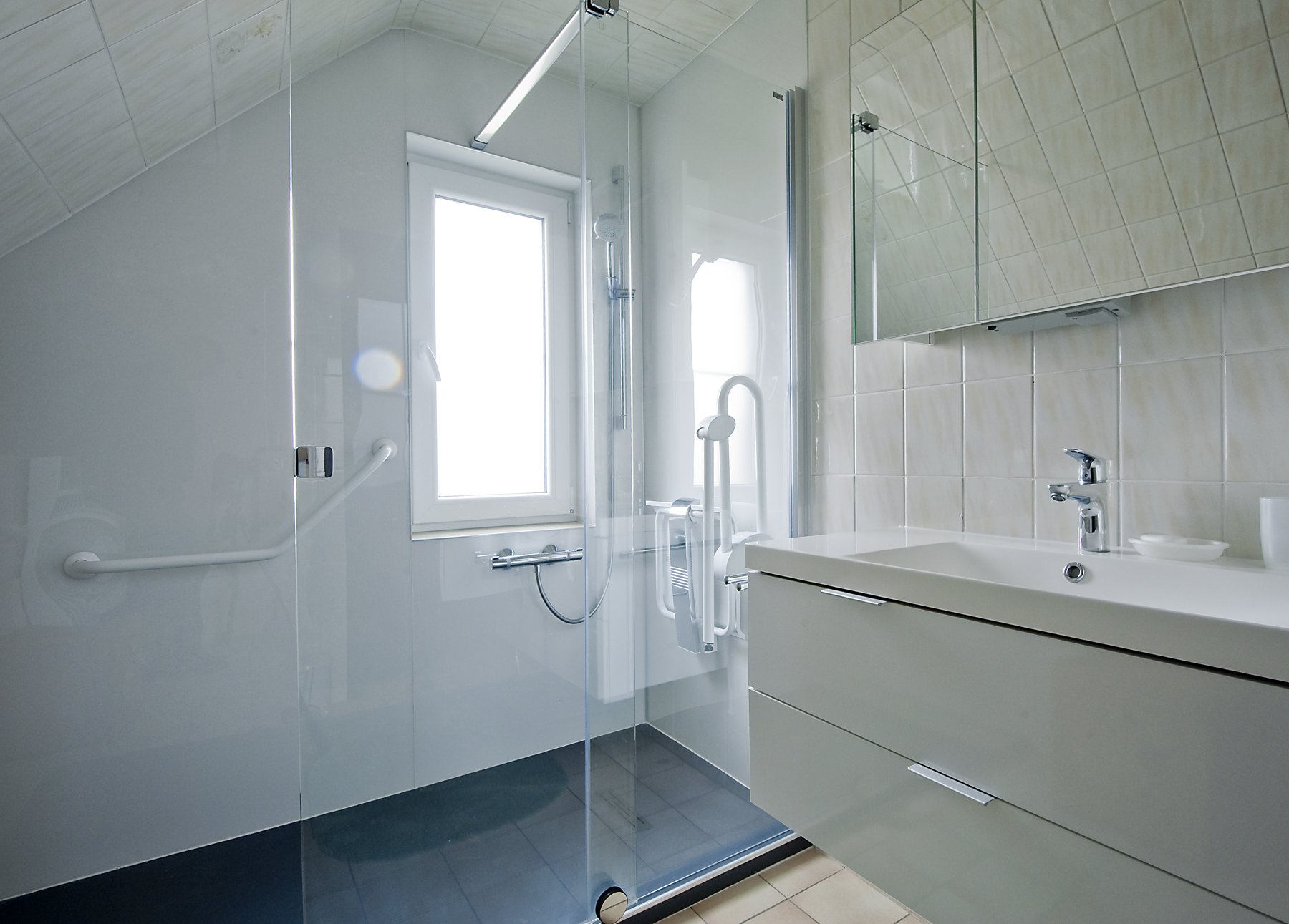 Salle de bain adaptée avec barres d'appui et meuble-vasque – réalisation RENOVO