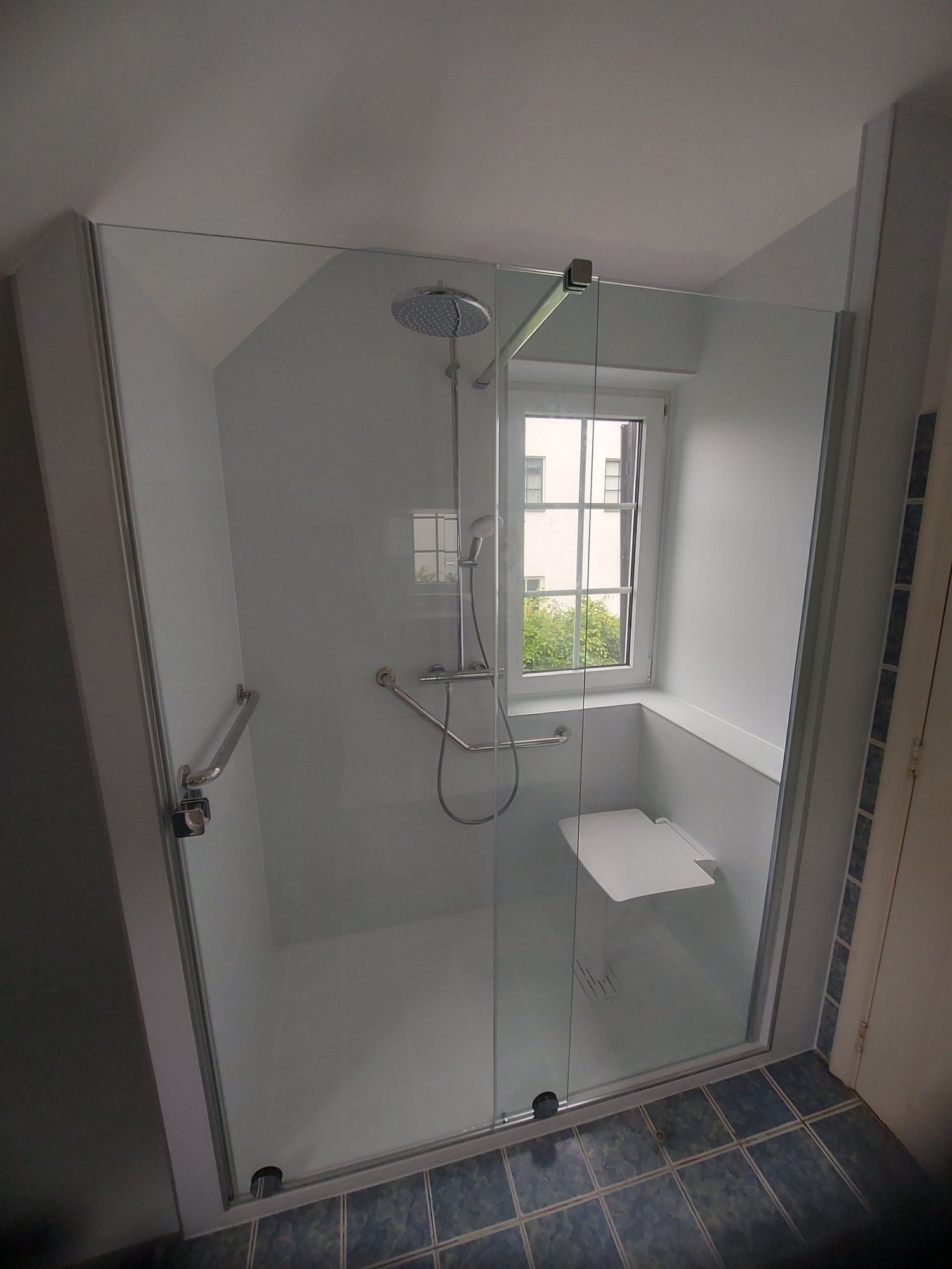 Douche adaptée seniors avec siège rabattable et barre d'appui sous fenêtre – réalisation RENOVO