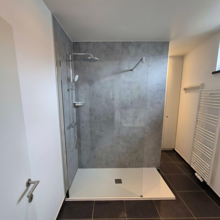 Après : douche walk-in avec panneaux muraux aspect béton gris et receveur extra-plat blanc – RENOVO